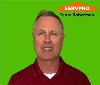 A smiling man on green background with a SERVPRO logo